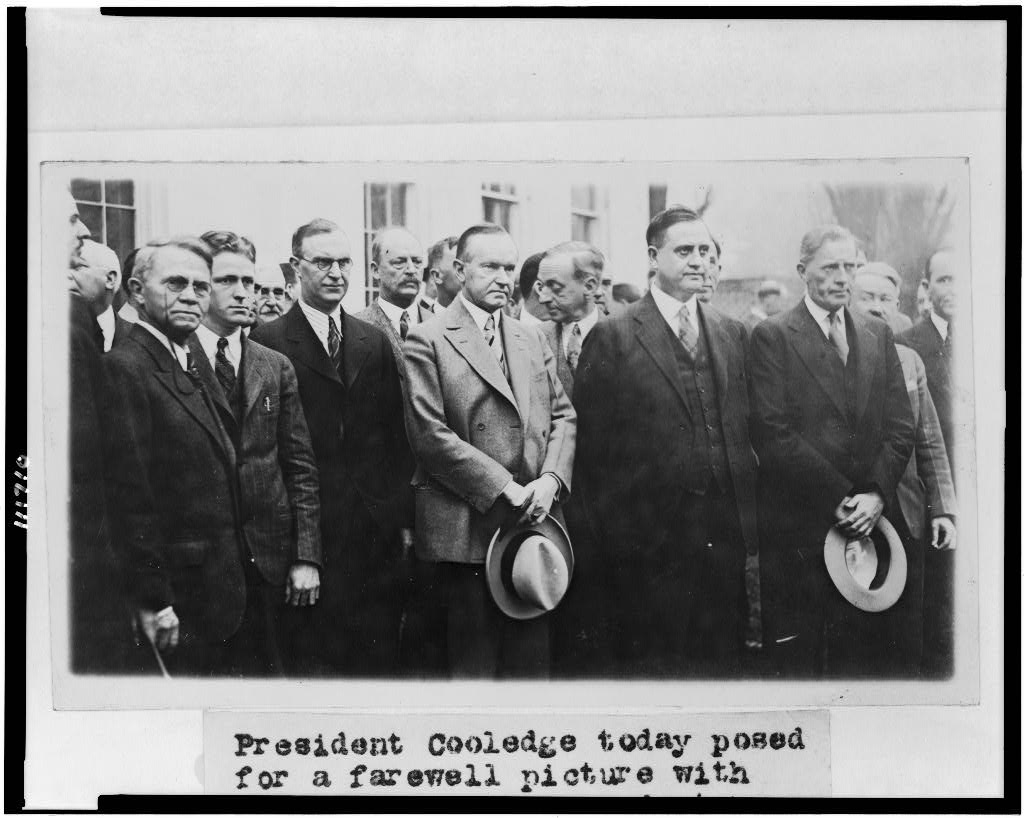 Coolidge standing for the farewell picture with White House correspondents, February 26, 1929. 