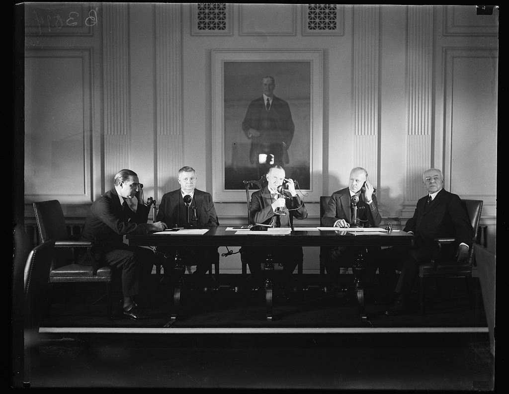 Pictured here in the Chamber of Commerce Building in Washington, D.C., from L to R: Don Mariano de Amoede y Galaremendi (Spanish Embassy, Washington); Under Secretary of State J. Reuben Clark; President Coolidge, speaking to King Alfonso; Walter S. Gifford, president of AT & T; and Joseph H. De Frees, chairman of the board, U.S. Chamber of Commerce. The man in the portrait above them is businessman Harry A. Wheeler, the first chairman of the U.S. Chamber of Commerce. 