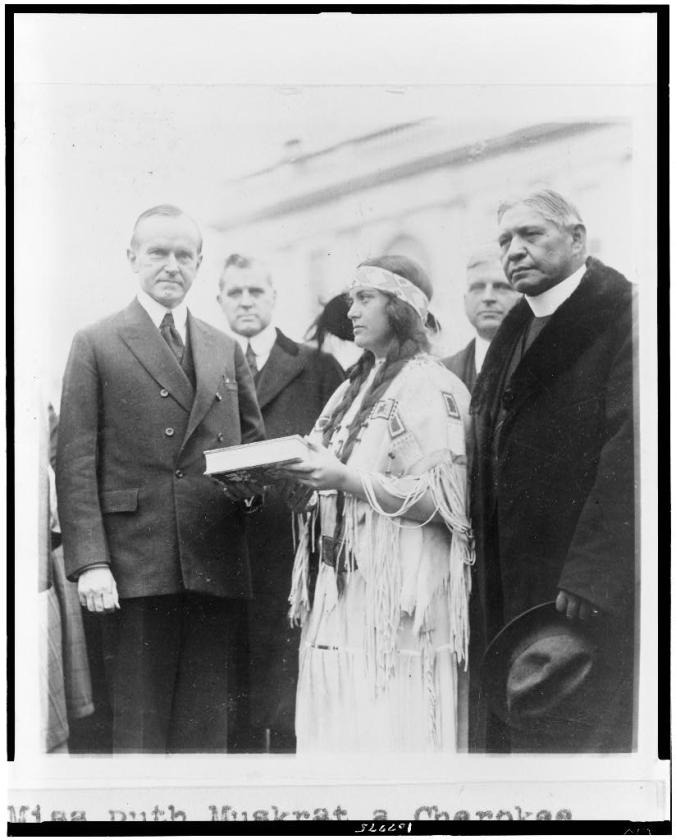 Miss Ruth Muskrat, a Cherokee Indian, presents Mr. Coolidge with a copy of The Red Man in the United States, a survey of the present day American Indian 12-13-1923