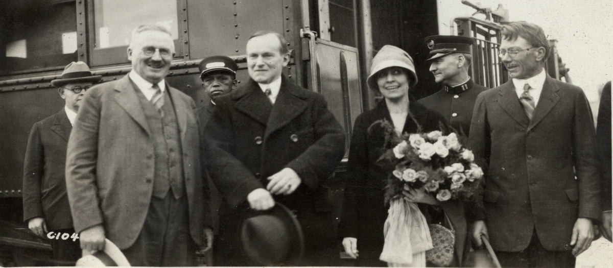 The Coolidges arrive in Rapid City, South Dakota, late afternoon on June 15, 1927. Here they are welcomed by Senator Norbeck (left) and Representative Williamson (right). 