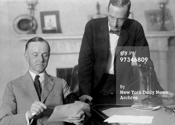President Calvin Coolidge penning his first official public document while his private secretary Clark watches 8-5-1923